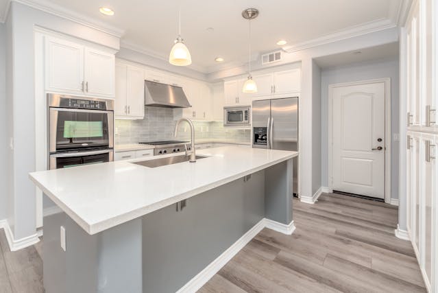 a white and grey kitchen with a large island